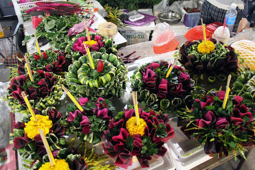 small rafts out of banana tree trunks decorated with flowers and incense sticks