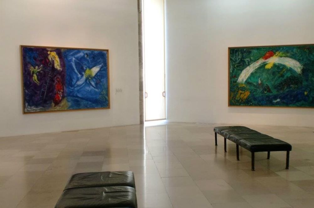 inside the art museum. Black chair in the middle with two art works in the wall- Things to do in Nice, France