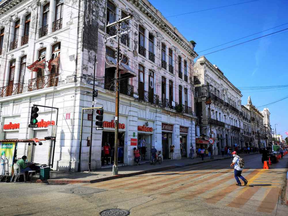 people in the street with old structural building on side