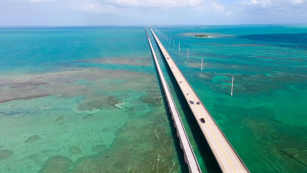 aerial view of a road with vehicle offering stunning views of the turquoise waters of the Gulf of Mexico and the Atlantic Ocean -Best road trips in the world