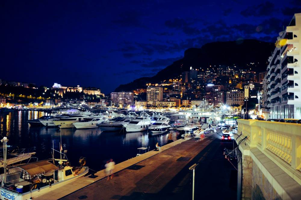 coast view showing yacht on side of the body of water during night time

