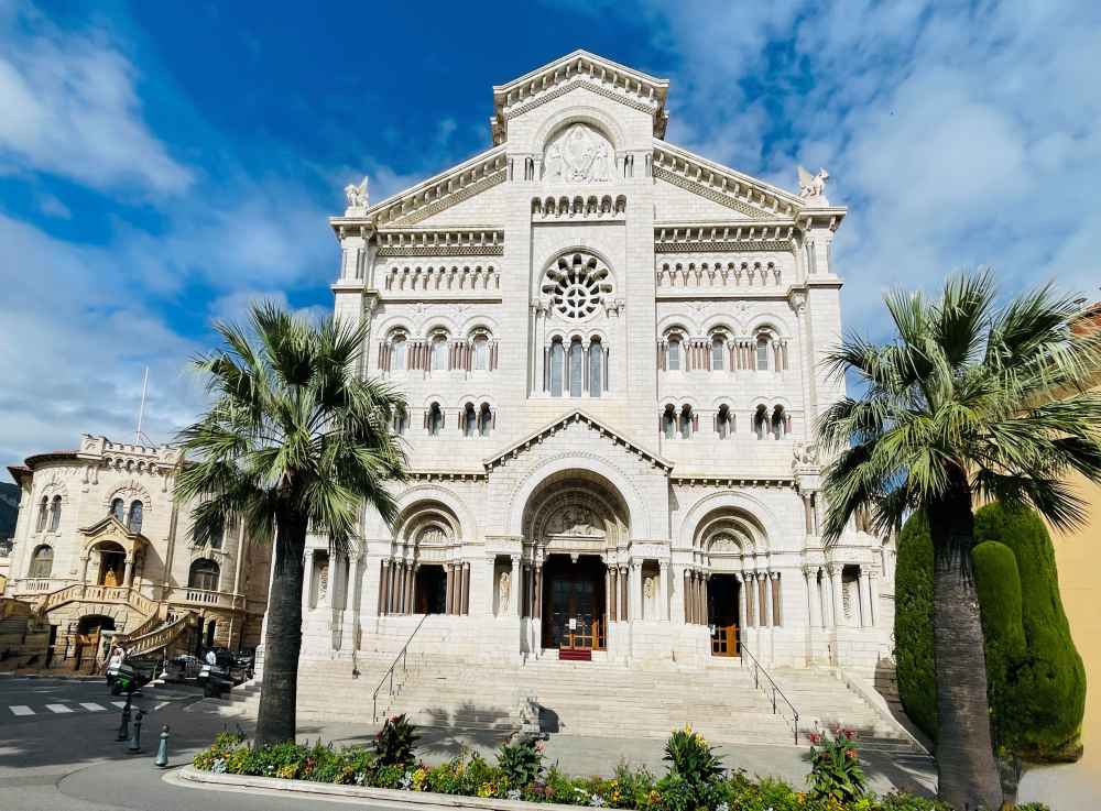 front view of an old architectural building with two palm trees in front - Things to do in Monaco 