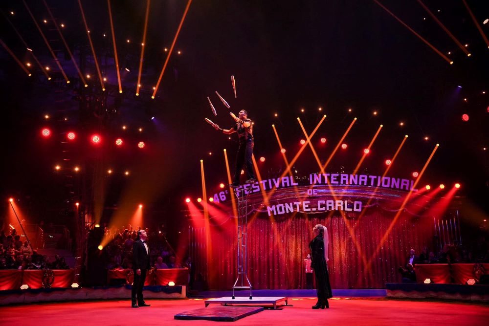 man in middle doing his stunt in circus in front of crowd