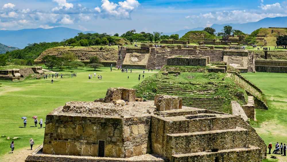 ancient ruins in a green field - best cities for nomads