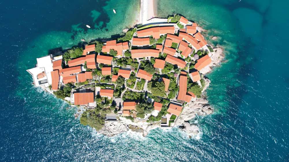 aerial view of a city showing orange roof surrounded by body of water 