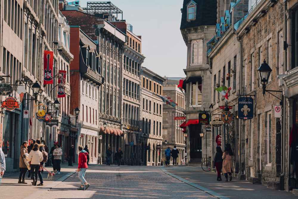 people walking in the street with old structure buildings