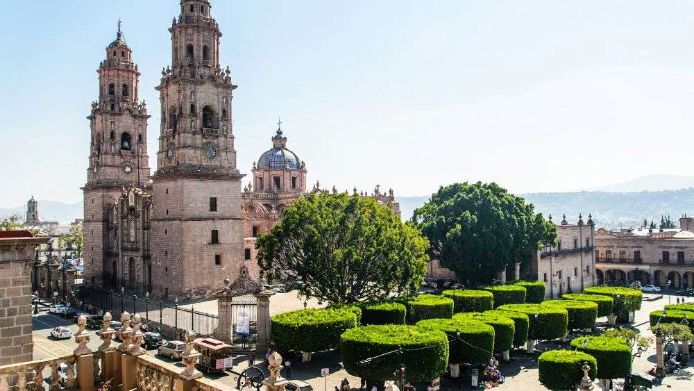 Aerial view of the city showing the tall church surrounded by green trees- 25 Best Places to Visit in Mexico