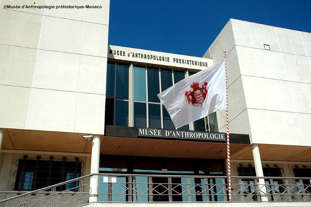 front view of a white building with flag in front