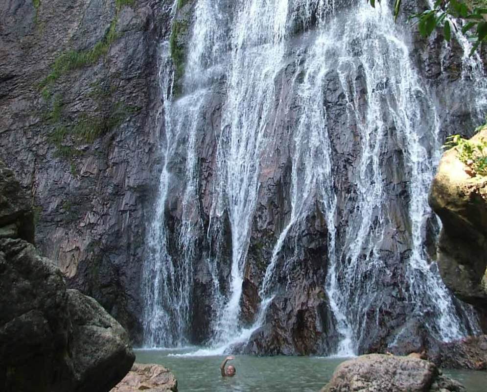 someone is swimming in the waterfalls