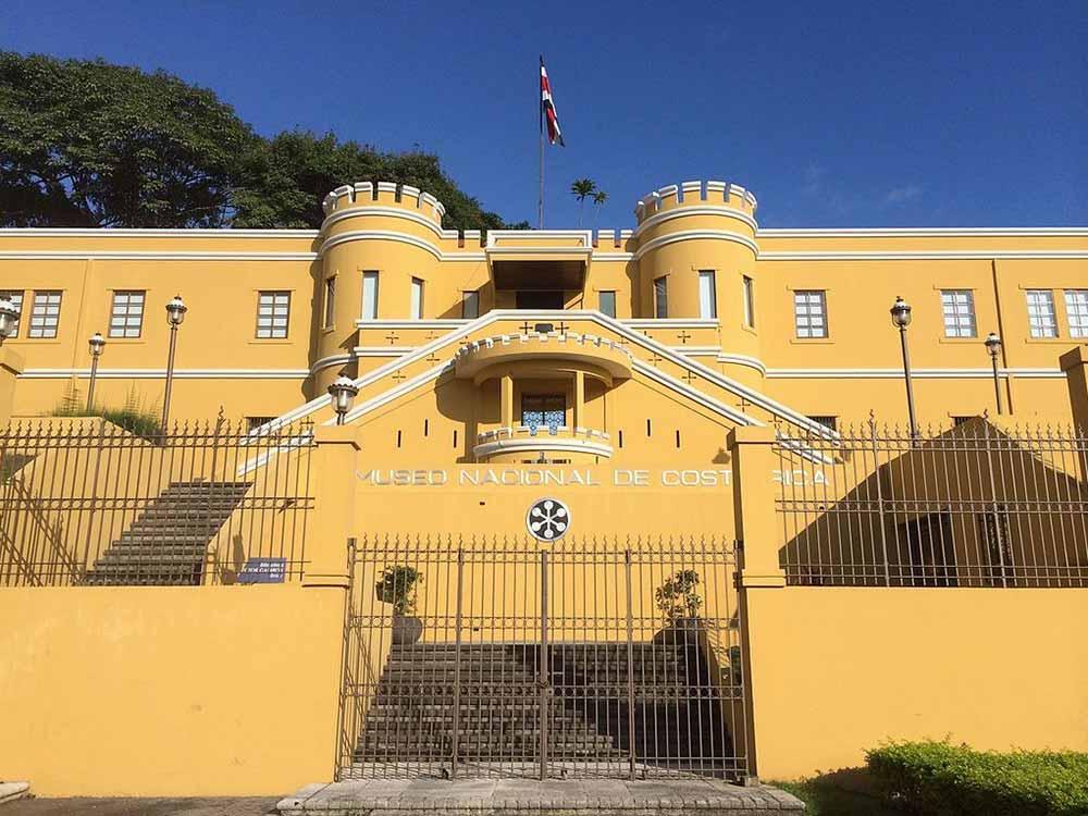 Front view of a yellow big building known as the national museum of costa rica