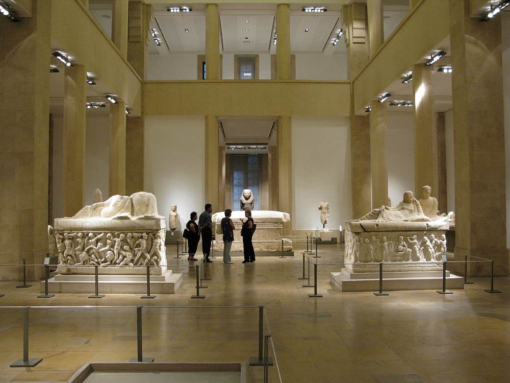 people talking inside the museum surrounded by off white statues - Oldest Cities in the World to Visit in 2025