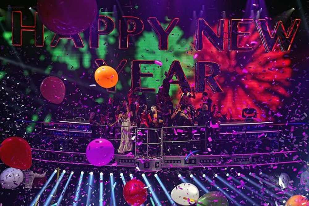 new year celebration with people in a stage with confetti and balloons