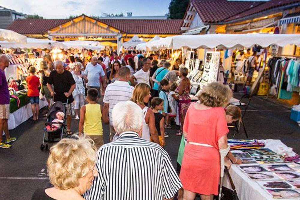 people walking and looking around inside a night market- Best Things to Do in Cannes