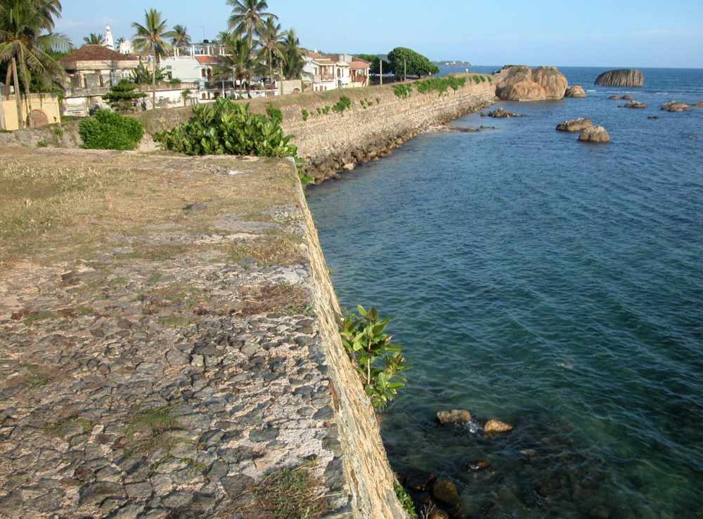 stone pathway in between the houses and ocean