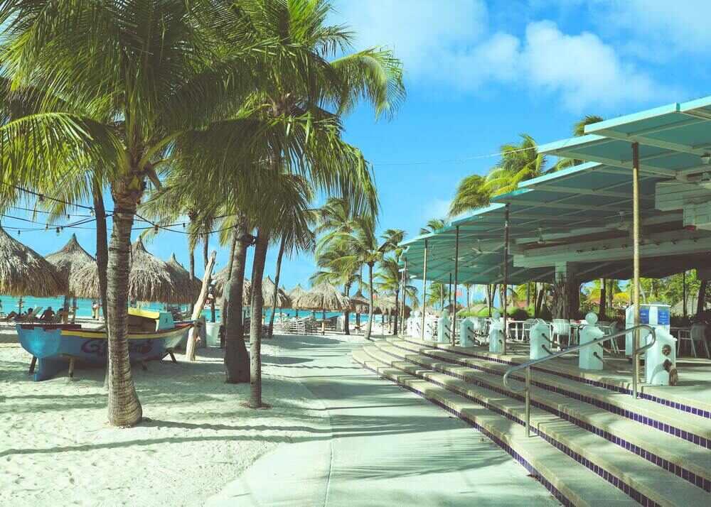 pathway in between the sand and restaurant in Oranjestad, Aruba