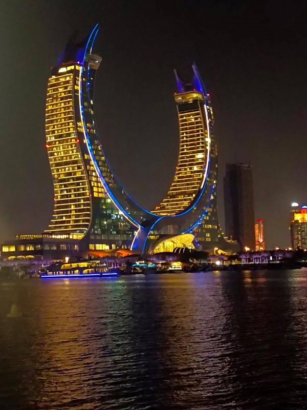 u-shape building near body of water during night time