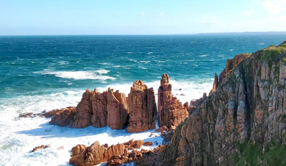 brown rock formation at the beach - Exploring the Sydney to Melbourne Coastal Road Trip