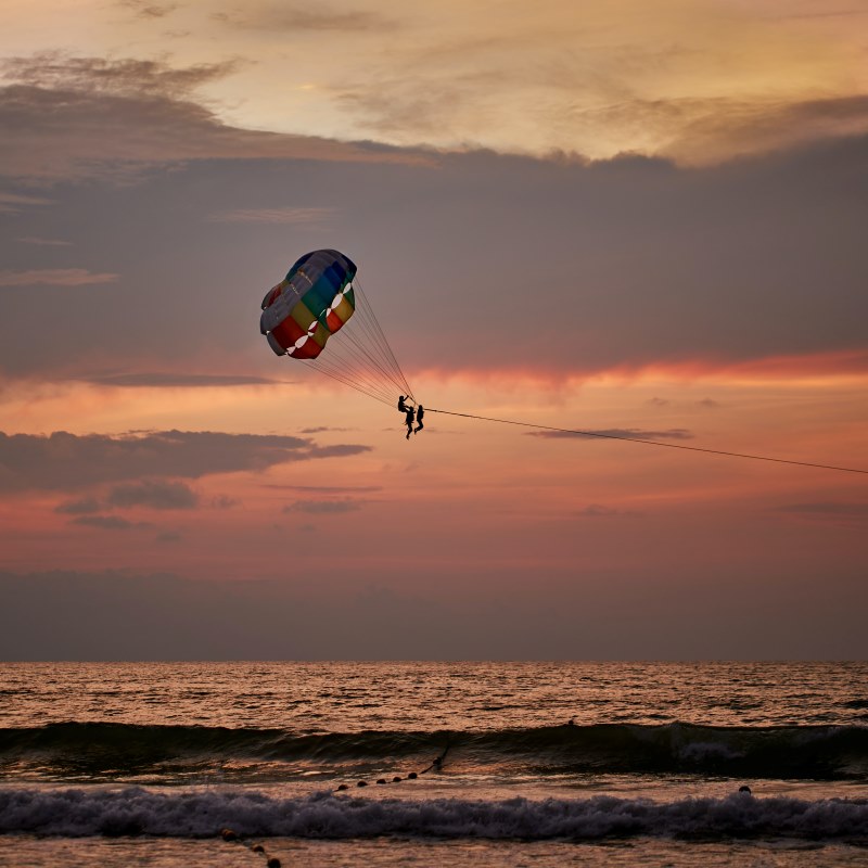people are parasailing during sunset