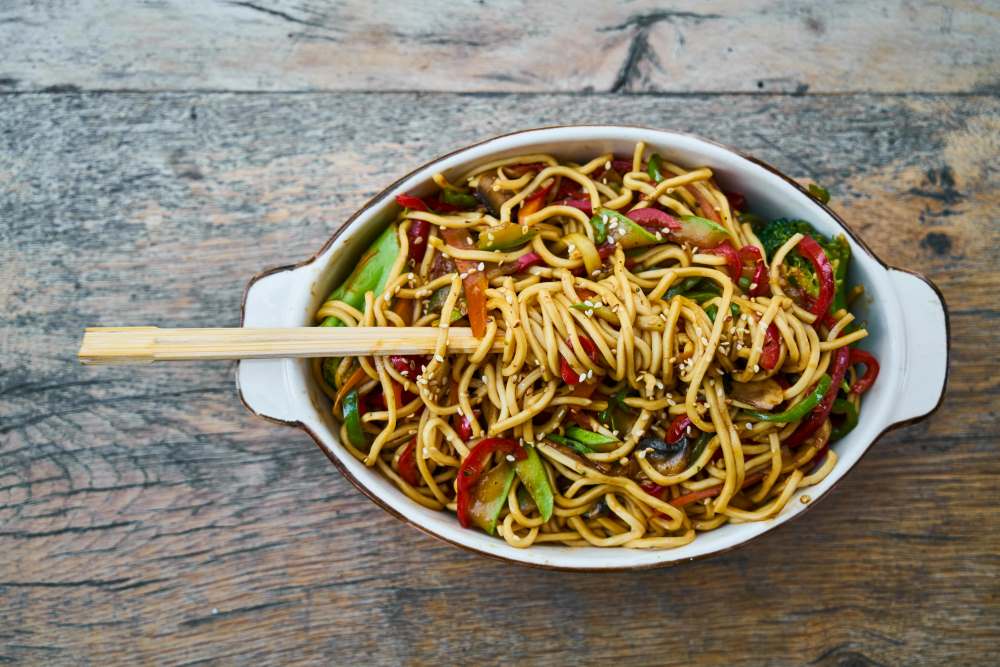 noodles in white dish on top of wooden table -phuket vs krabi