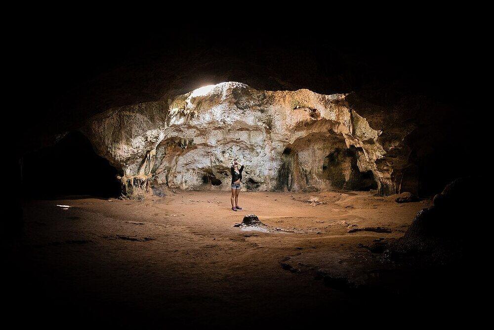 a woman inside and in the middle of the Quadariki Cave