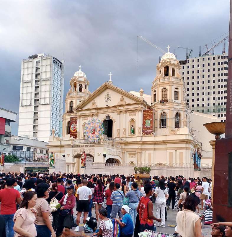 people  walking in front of the church and some are selling goods