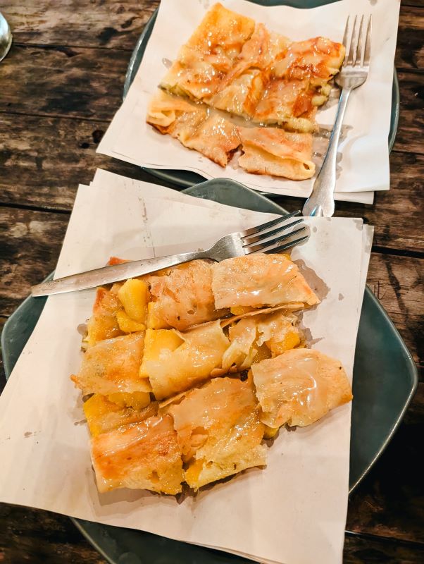 two plates of roti filled with condense with silver fork on the side - phuket vs krabi