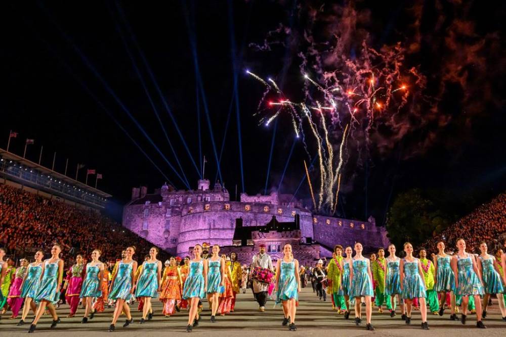 people performing in front of the castle with fireworks display- Things to Do in Scotland