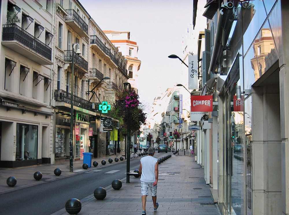 man walking in the srteet surrounded by different shops -Best Things to Do in Cannes 