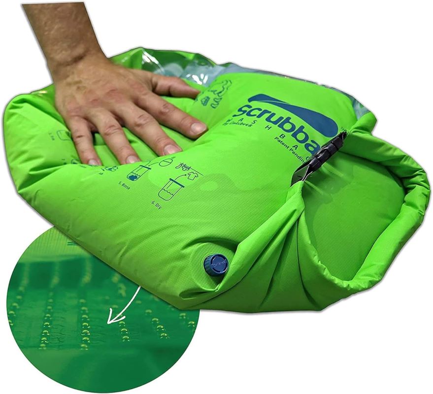 hand squeezing green portable laundry wash bag