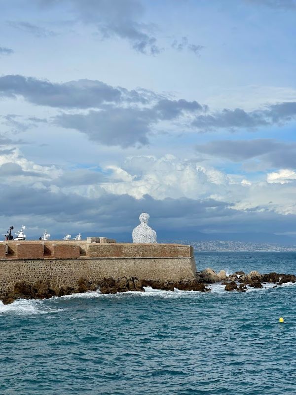 statue in front of the ocean