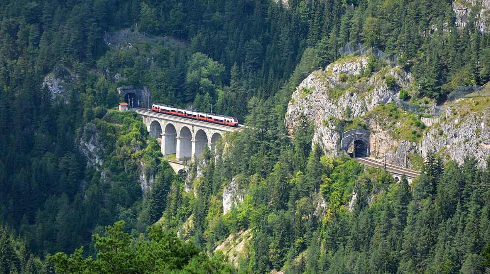aerial view of a red train in a top of a mountain railway