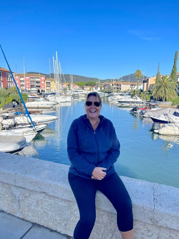 my picture sitting at a cemented bench with yacht and body of water on my back
