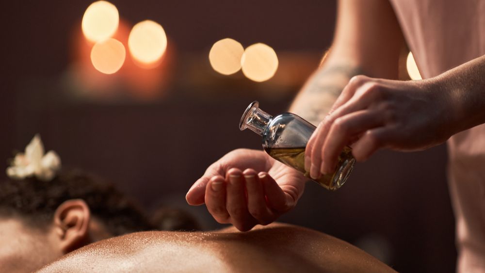 hand pouring oil on top of a back of a woman- Best Things to Do in Antibes