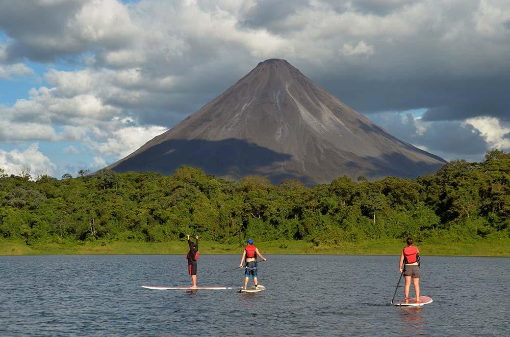 three man stand up paddle boarding lake arenal