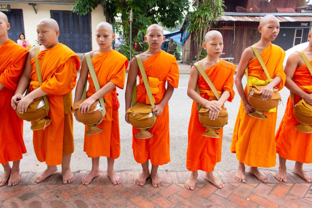 young mens in orange clothes and bag skinned head- facts about thailand
