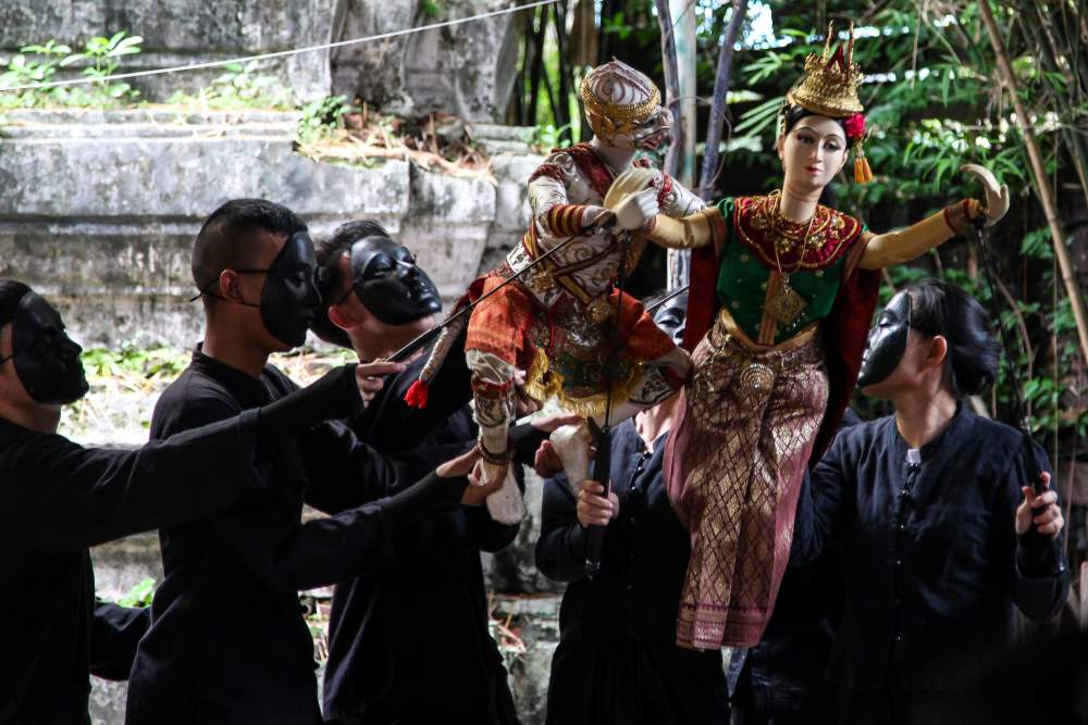 people in black playing with puppets- facts about thailand
