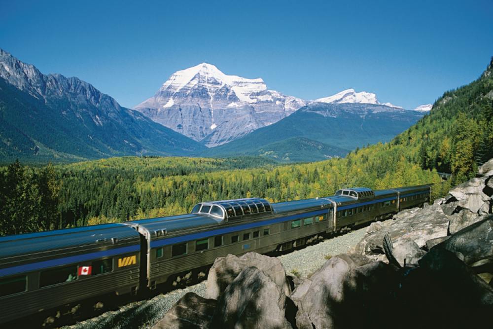 train with fields and mountain view - luxury train rides