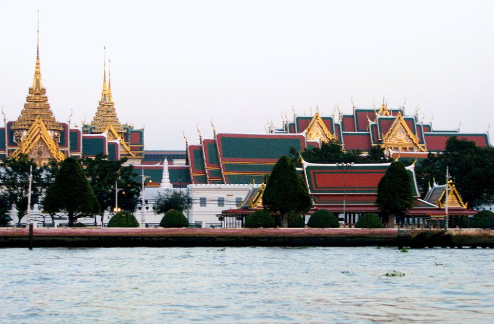 red and green roof temple beside a body of water