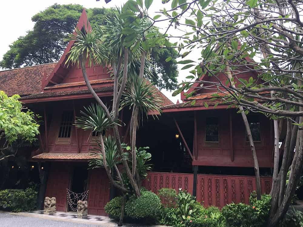 maroon building with trees and plants beside it