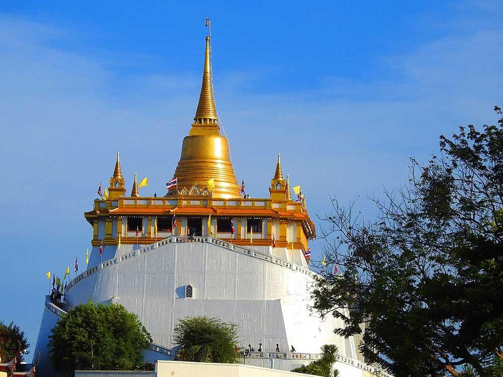 golden bell shape tower top above a white building