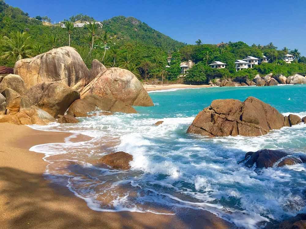 Blue beach with rock formation beside it