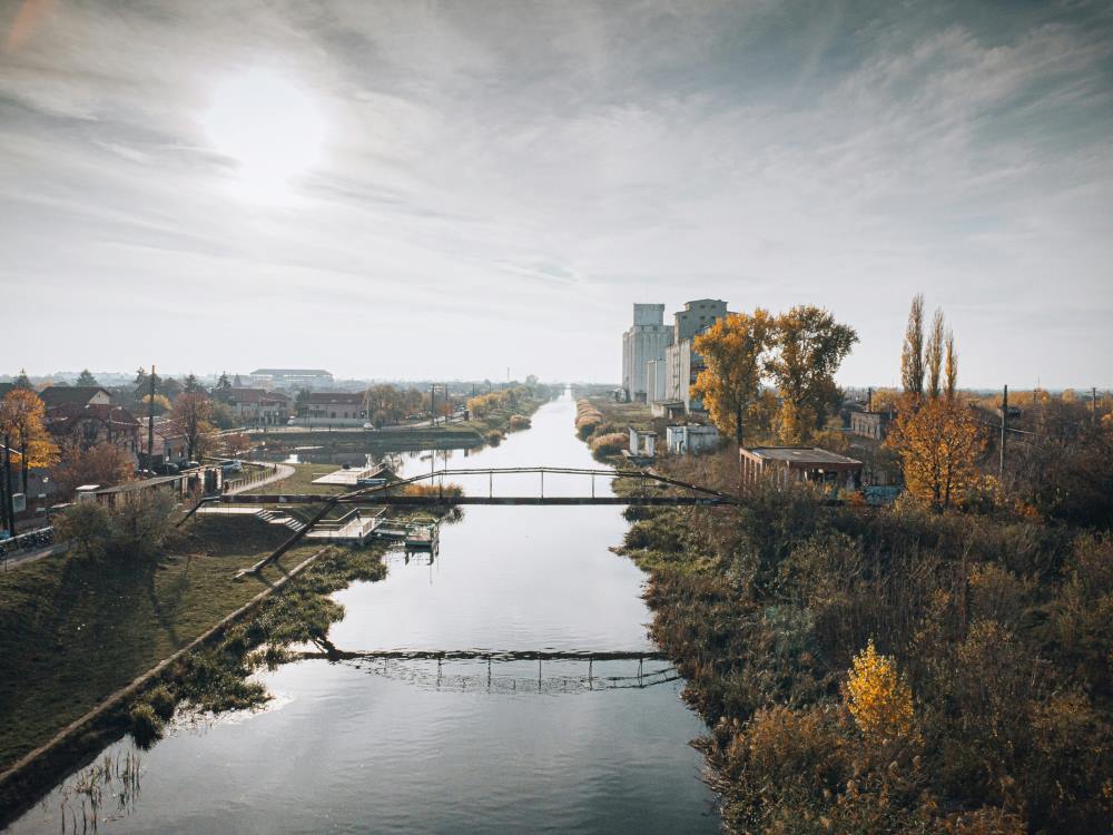 a river in between in city surrounded by buildings and trees- romania digital nomad visa