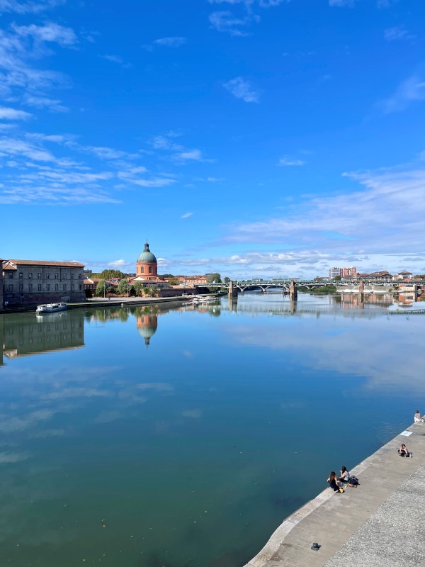 body of water with bridge and building at the back