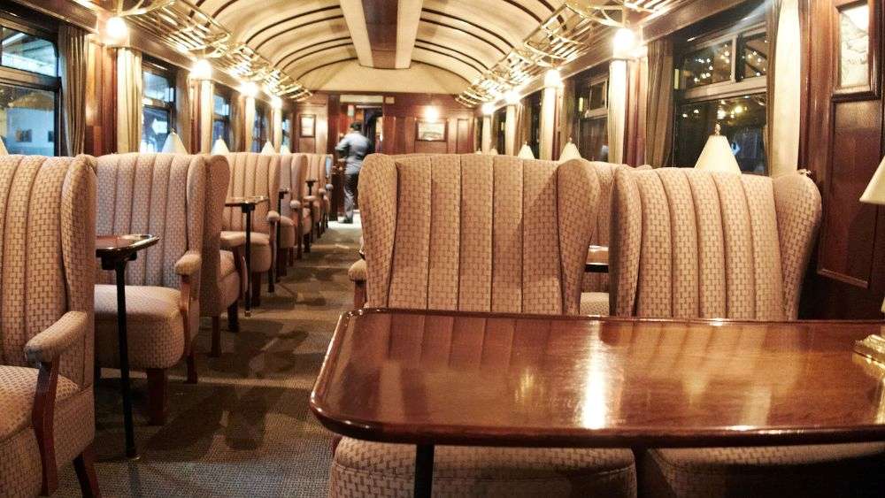 inside luxury train with comfy chairs and desk