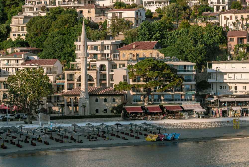 buildings, cafe and umbrellas near the body of water - montenegro digital nomad visa