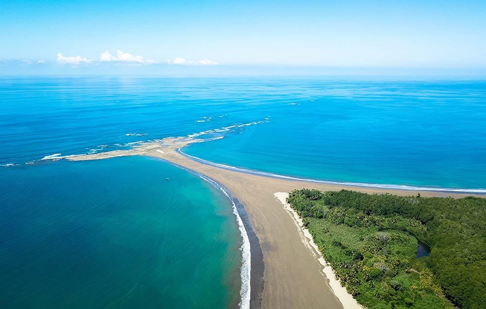 sand looks like a whale tail surrounded by a blue ocean