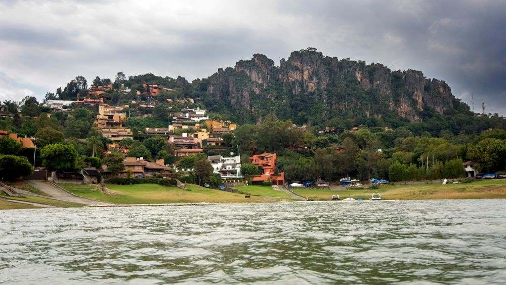 Community with houses and building near the mountain surrounded by trees and in front of body of water- 25 Best Places to Visit in Mexico