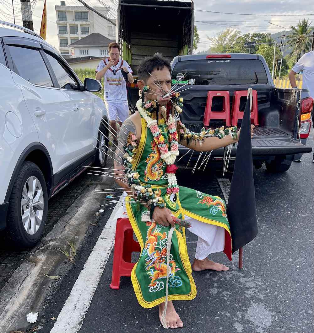 man with swords & knives through his cheeks for the vegetarian festival