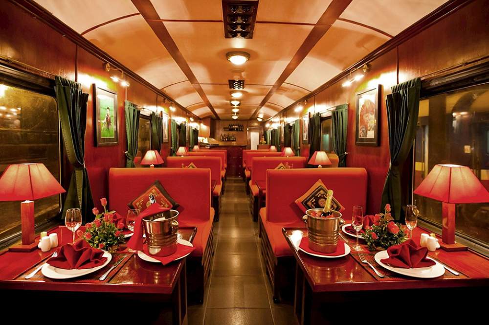 inside train with red chairs and table with romantic set up for dinner