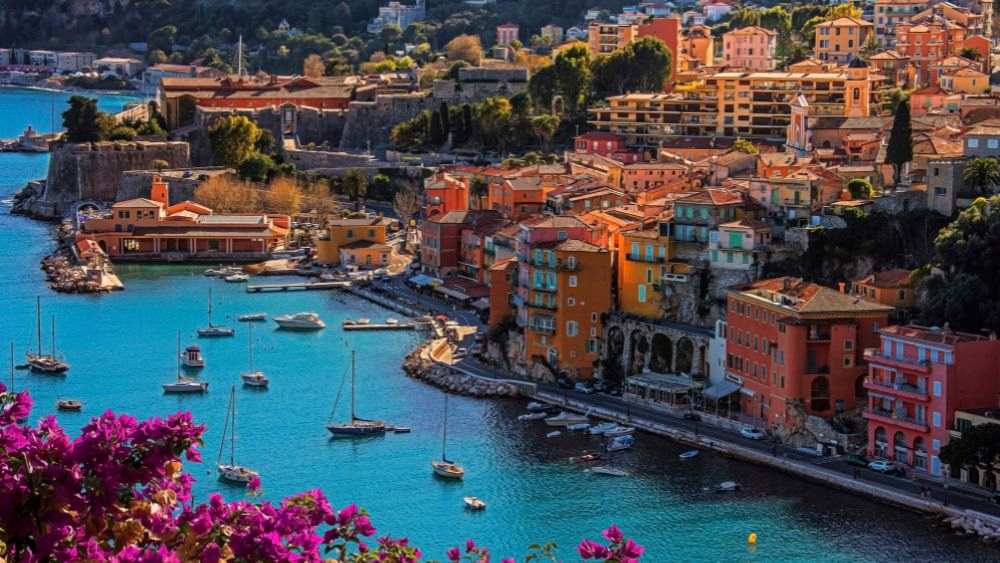 aerial view of the city with colorful houses and buildings near the ocean with yacht and boats